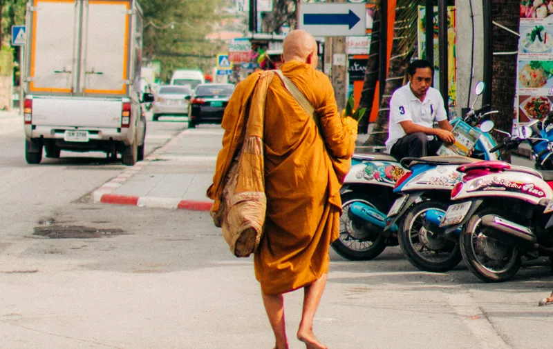 En munk i Bangkok på morgonens almosrunda