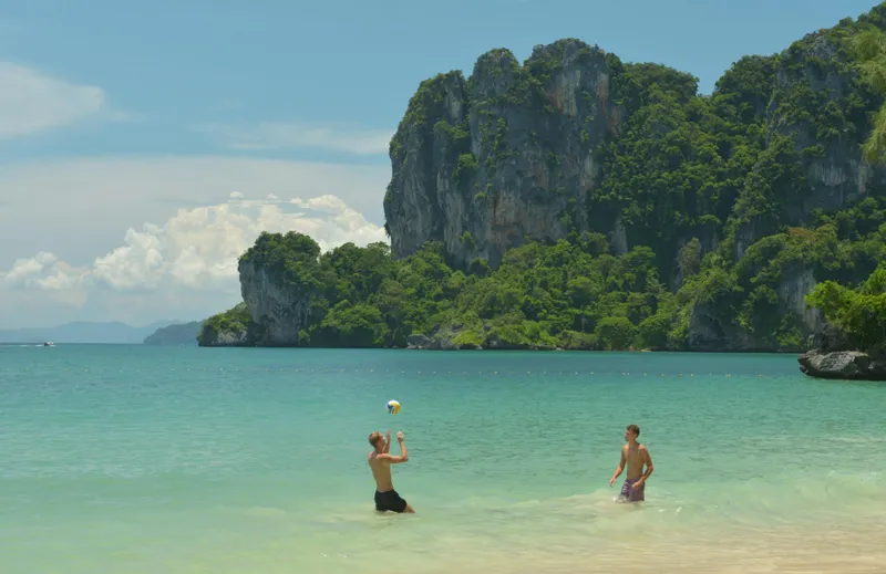 Två män spelar beachvolleyboll i havet i Ao Nang